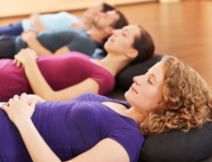 Groupe de personnes en seance de sophrologie allongées.
